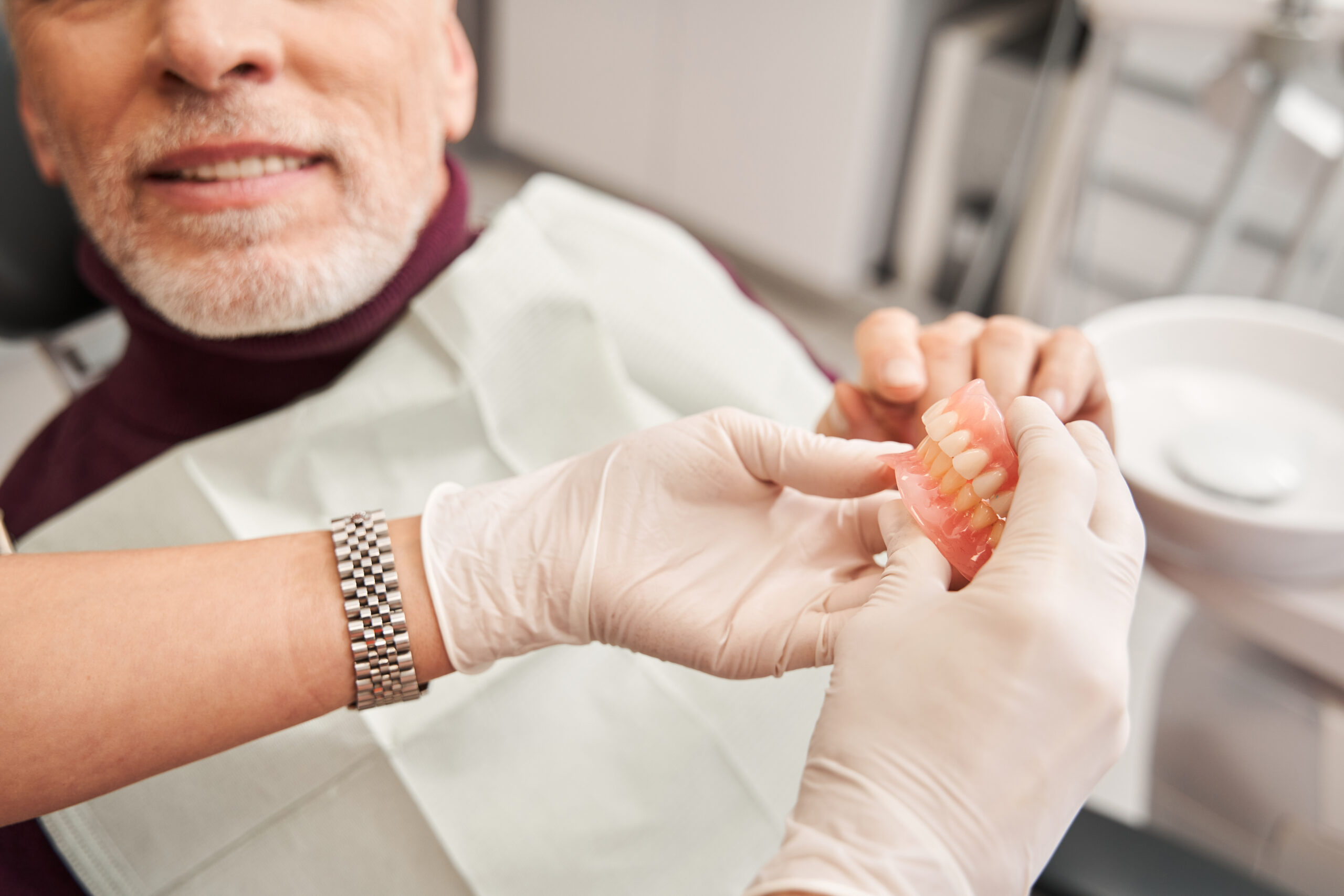 Dentist showing a denture to a patient during a consultation